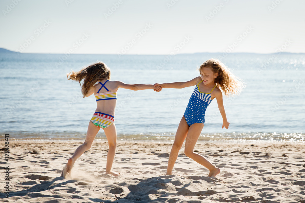 Two sisters dancing on a sandy beach Two sisters dancing on a sandy beach