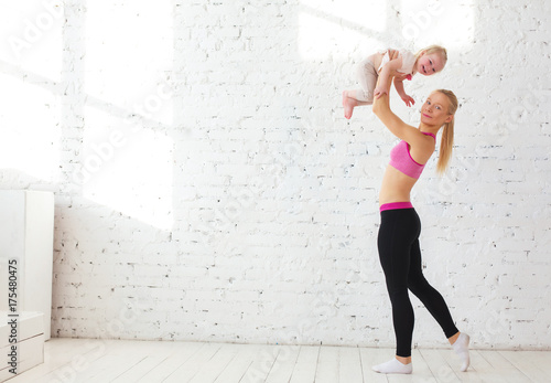 attractive fitness woman mother and baby gymnastics yoga exercises trained female body lifestyle white background