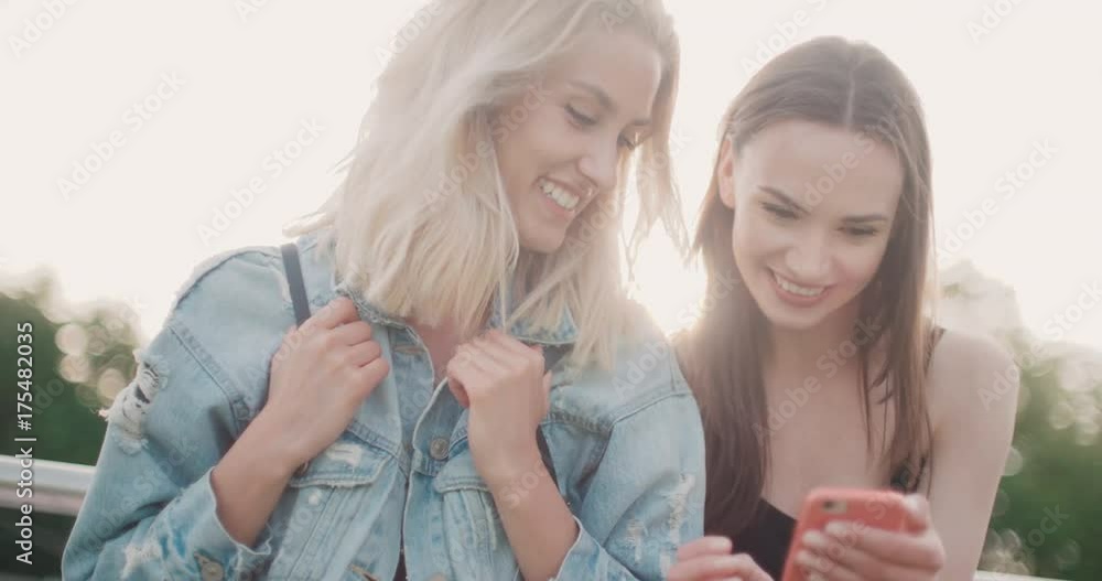 Beautiful young women watching photos on a mobile phone.