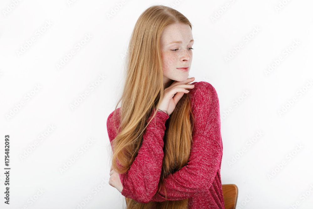 Beauty portrait of young adorable fresh looking redhead woman with gorgeous extra long hair. Emotion and facial expression concept.