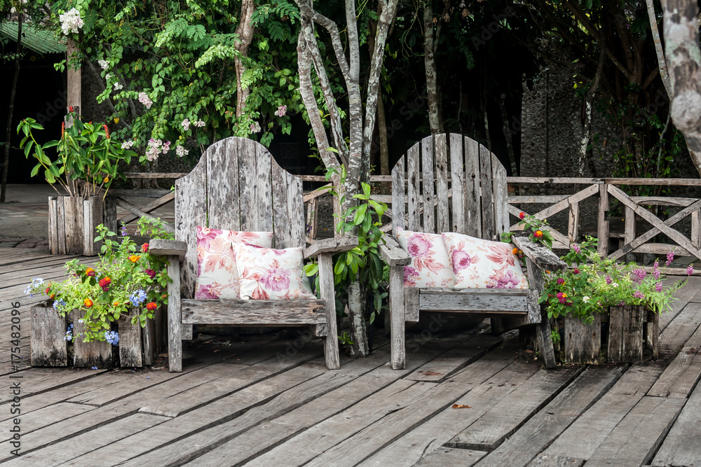 Rustic armchairs with two white pillows with pink flowers