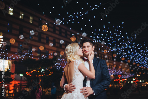 Evening photography of the newlyweds on the streets of the city that lit the lights.