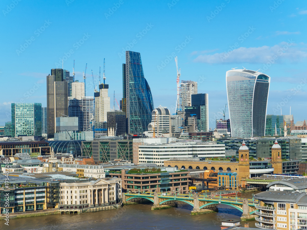 London skyline with a view of Southwark Bridge and skyscrapers of the north bank of the River Thames on a sunny day.