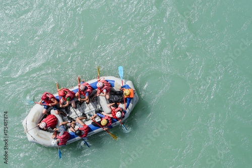 Top view of the boat with people rafting along the mountain river