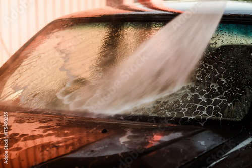 Foto Washing car in a car wash self service station