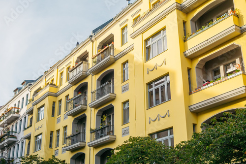 yellow apartment building in a street at berlin