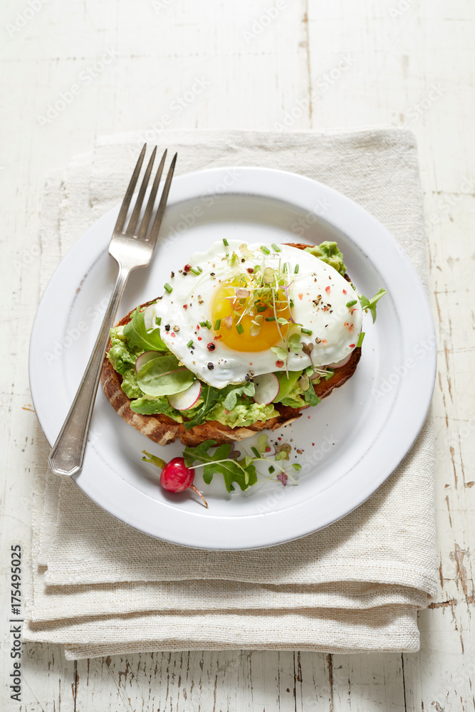 Avocado toast with radish, fried egg and micro greens Avocado toast with radish, fried egg and micro greens