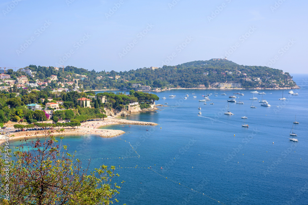 Beautiful daylight view from top of mountains to luxury resort villefranche sur mer and bay on french riviera at mediterranean sea Cote d'Azur in France, beach with boats cruising on water.