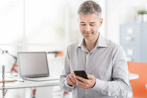 Businessman using a smartphone in his office