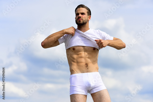 Health and fitness concept: man with fit body undressing
