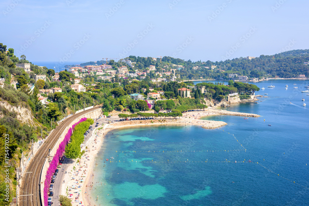 Beautiful daylight view from top of mountains to luxury resort villefranche sur mer and bay on french riviera at mediterranean sea Cote d'Azur in France. Railways and beach with people