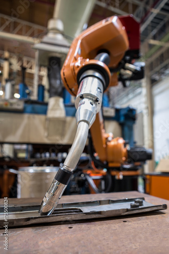 Orange robot welding is standby in teaching mode