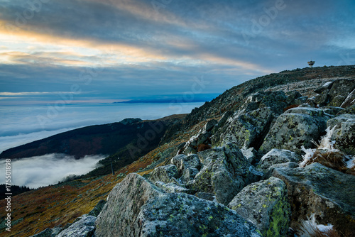 Cloud inversion from a mountain top - beautiful autumn landscape with thick blanket of rolling clouds at sunrise
