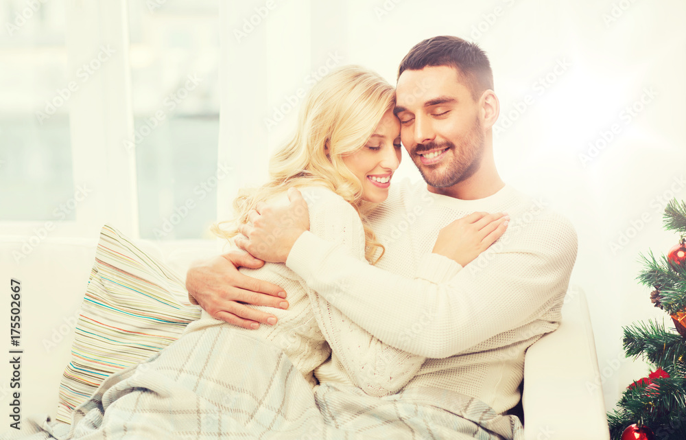 happy couple hugging on sofa at home happy couple hugging on sofa at home
