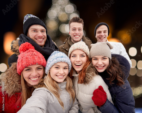 happy friends taking selfie outdoors at christmas