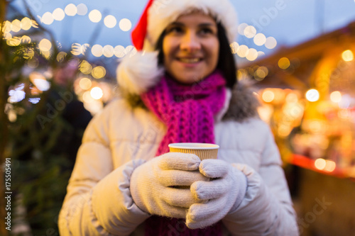 woman with cup of hot drink at christmas market