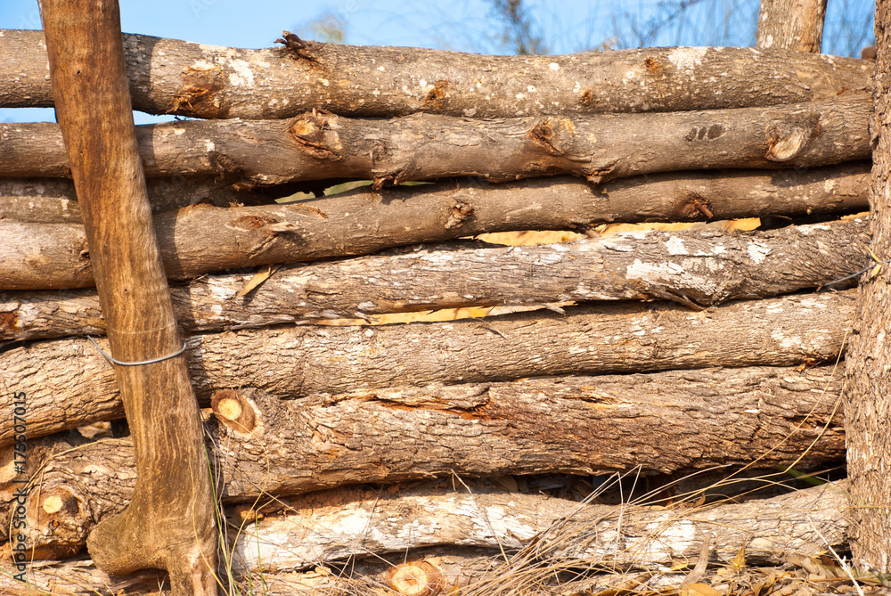 Shabby chic handmade fence from logs with blue sky. Rustic village autumn background. Shabby chic handmade fence from logs with blue sky. Rustic village autumn background.