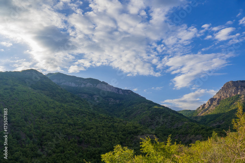 White clouds above blue mountains / Clouds in blue sky over green mountains covered with forests © lokomotiv110