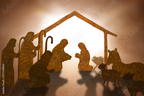 Obraz na plátně Christmas nativity scene including Jesus,Mary,Joseph,sheep and donkey ,Brown paper cut silhouette concept