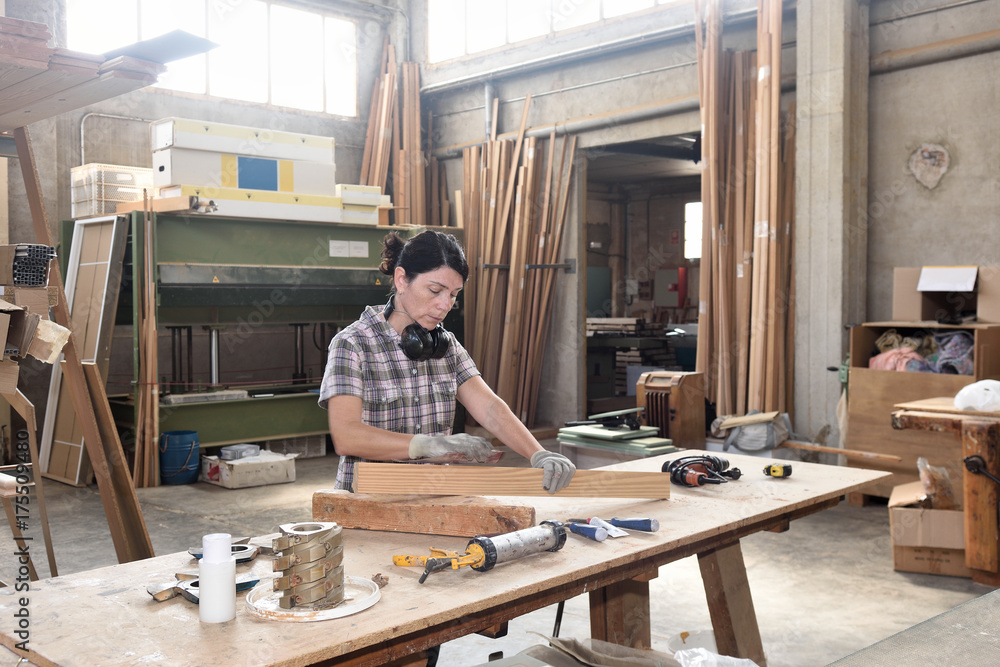 a woman working in a carpentry workshop,sand a woman working in a carpentry workshop,sand