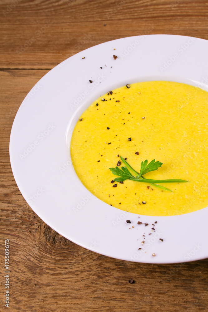 Creamy corn soup in white bowl, garnished with pepper, scallion and parsley. Vegetable soup, vertical Creamy corn soup in white bowl, garnished with pepper, scallion and parsley. Vegetable soup, vertical