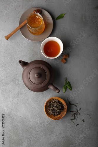 Tea and honey on concrete background