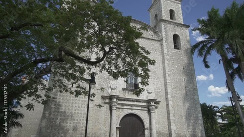 Vertical panoramic view on two columns with arches of high stone white catholic church in sunny summer day photo