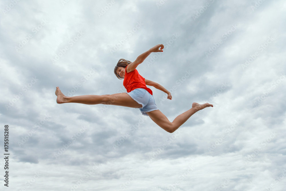 Fitness girl jumping against the background of the blue sky