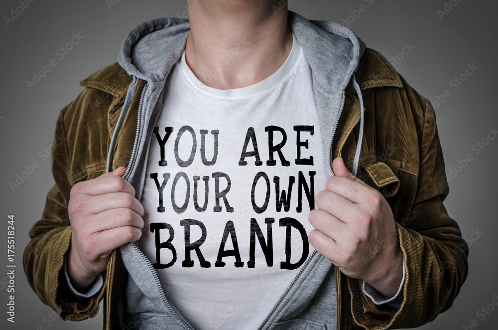 Man showing You Are Your Own Brand tittle on t-shirt. Personal branding concept. - obrazy, fototapety, plakaty 