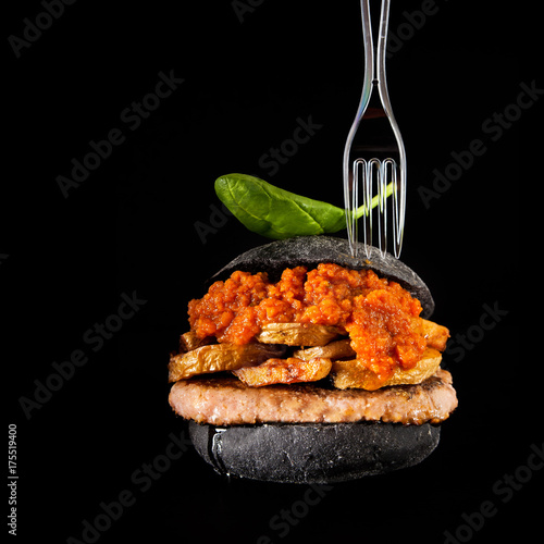 italian Black Burger with sausages Salamella , potato and vegetable sauce. plastic fork
