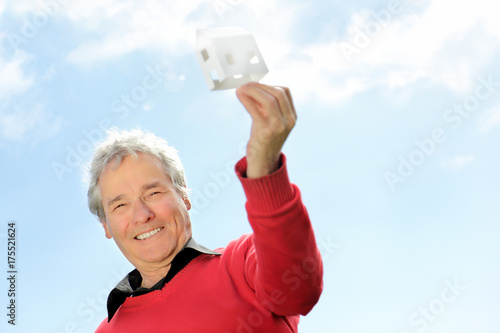 Series of a happy Senior Pensioner, imagining his new future home with a Little Paper house photo