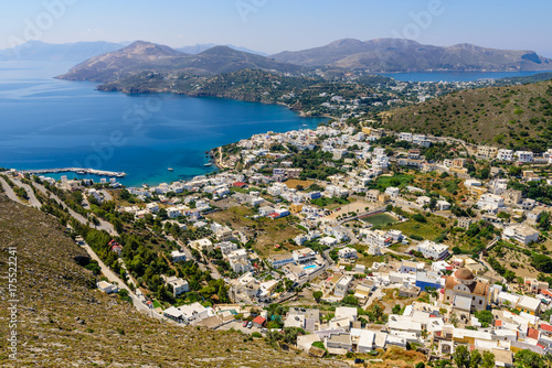 aerial view of the coastline and the Panteli village, a traditional Greek village with white buildings and fishing boats, Leros island, Greece © r_andrei
