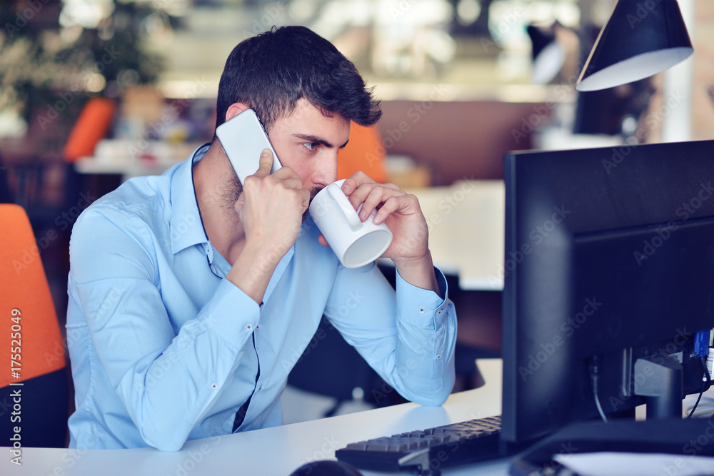 Businessman relaxing with legs up on desk, drinking coffee while dreaming about future at workplace in modern office. Businessman relaxing with legs up on desk, drinking coffee while dreaming about future at workplace in modern office.