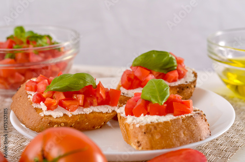 delicious bruschetta with tomatoes on plate on table close-up