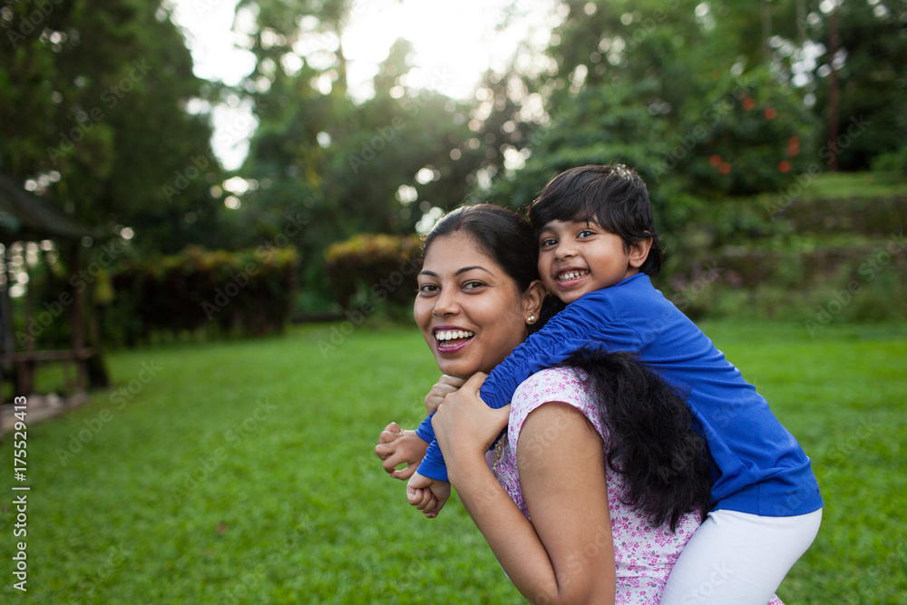 Little girl riding on her mother's back Little girl riding on her mother's back