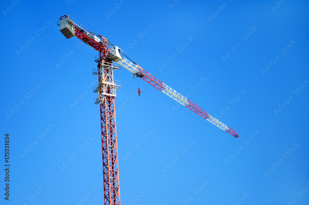 Construction crane. Red construction crane against a clear blue sky. Construction crane. Red construction crane against a clear blue sky.