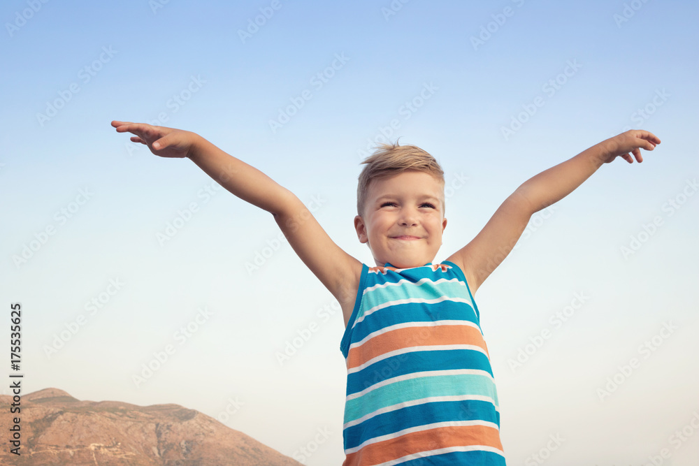Happy boy with raised arms against the sky. Happy boy with raised arms against the sky.
