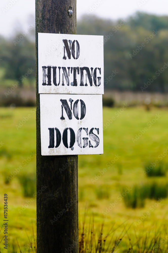 Signs on a fence around a field saying 