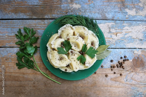 Boiled dumplings on a plate. Wooden rustic background. Top view. Copy space.