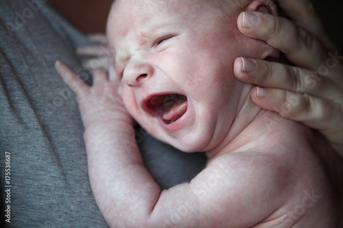 Newborn Baby Crying While Being Held photo