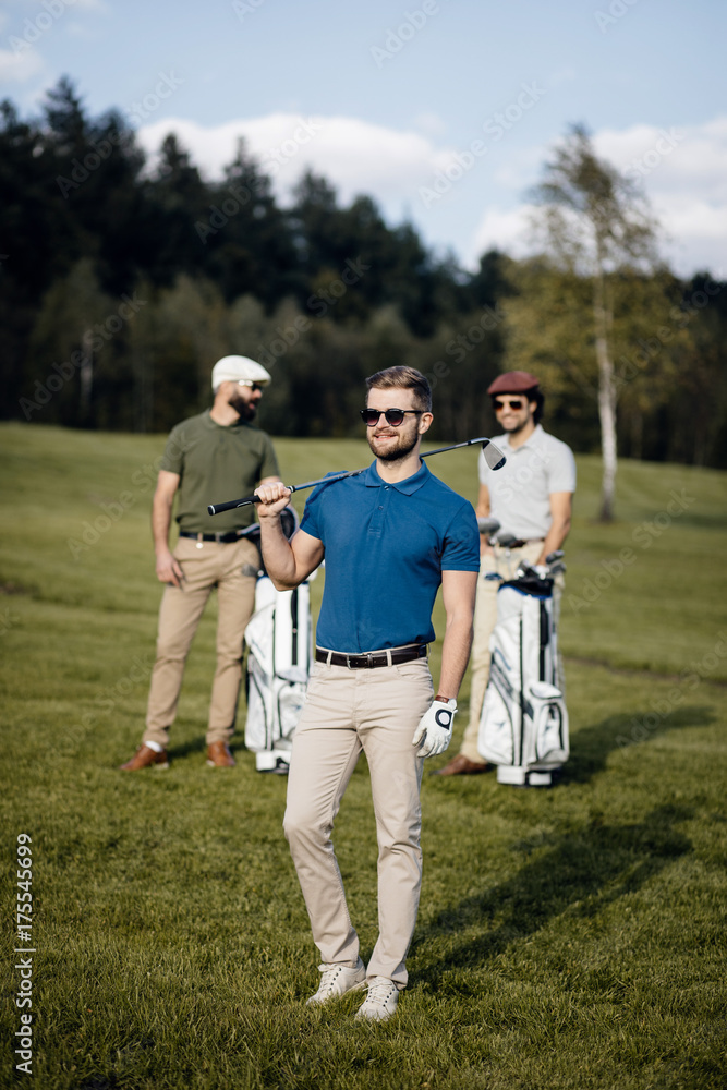 Golf player walking and carrying bag on course during summer game golfing Golf player walking and carrying bag on course during summer game golfing