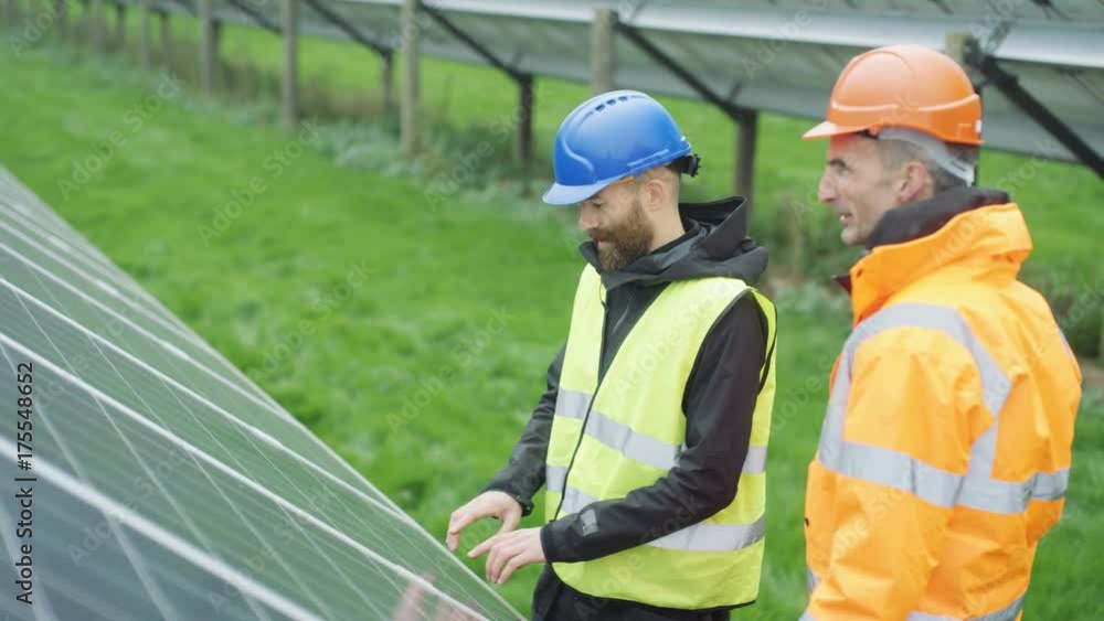 Technicians checking the panels at solar energy installation Technicians checking the panels at solar energy installation