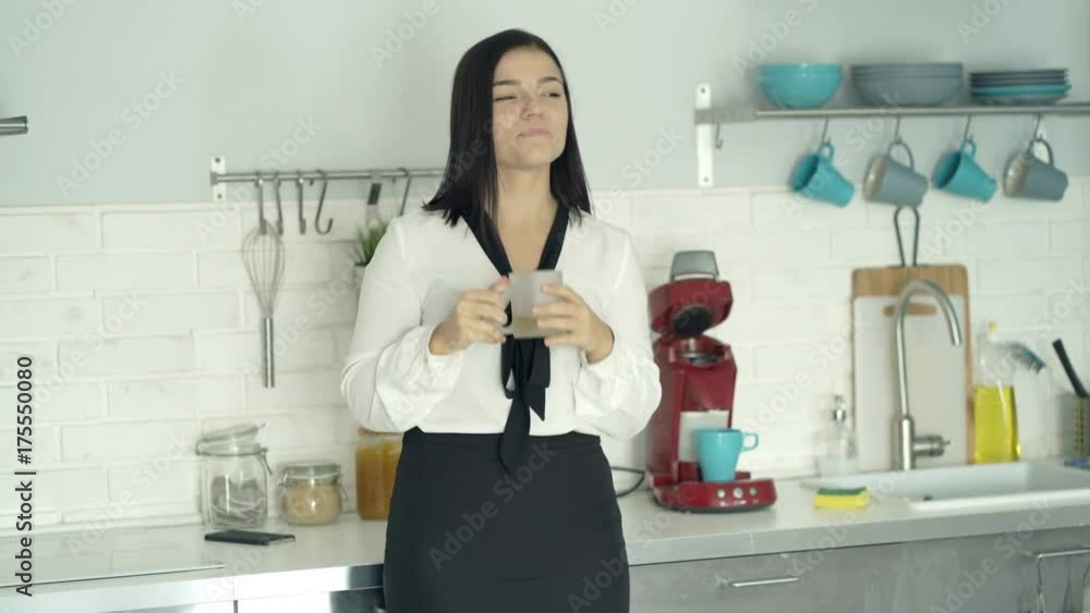 Happy businesswoman relaxing and drinking beverage in kitchen
Happy businesswoman relaxing and drinking beverage in kitchen