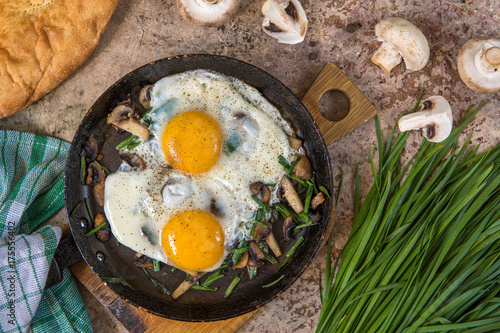 Fried eggs with mushrooms and jusai (allium ramosum). Breakfast in azian style, top view photo