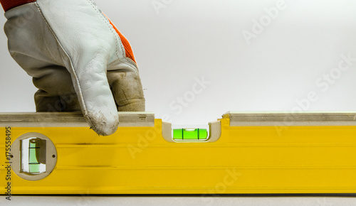 Yellow building level in hands. Isolated on a white background