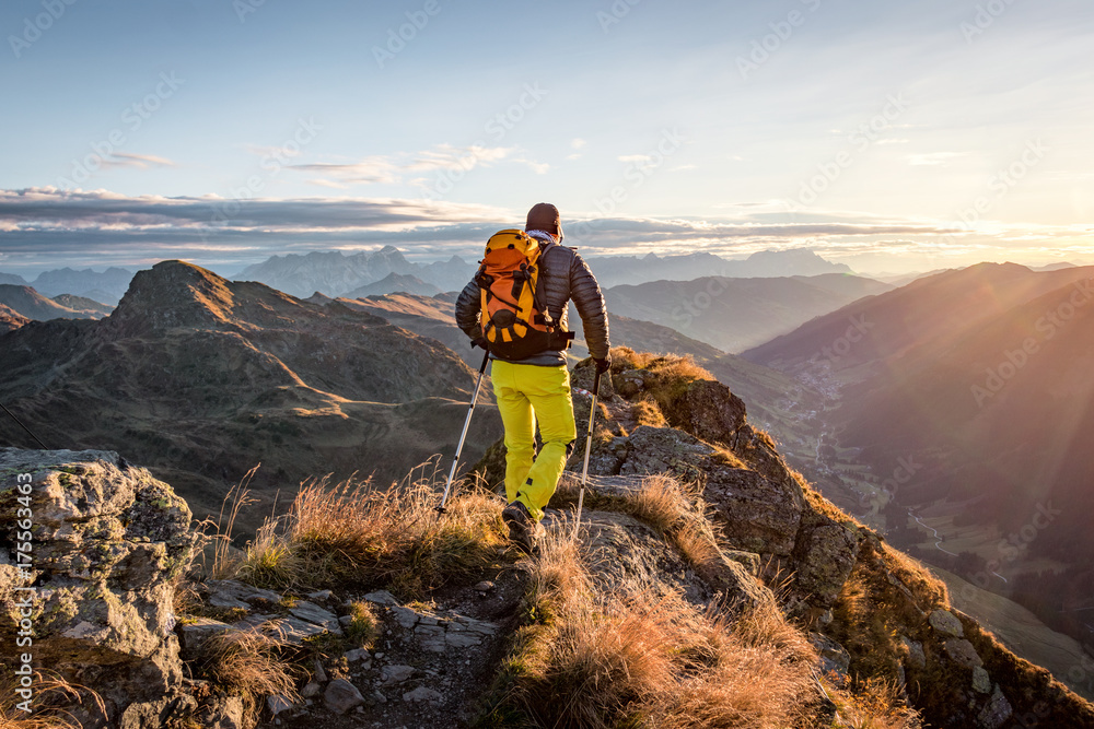 Mountaineer hiking in the mountains in morning light - obrazy, fototapety, plakaty 