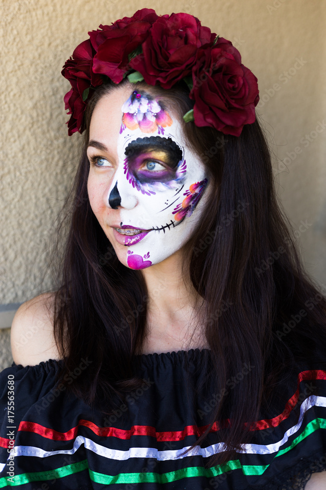 Sugar Skull Halloween Makeup. Dia de los Muertos. Brunette girl with  Mexican style Halloween face painting. Red rose, flower hair decor foto de  Stock | Adobe Stock