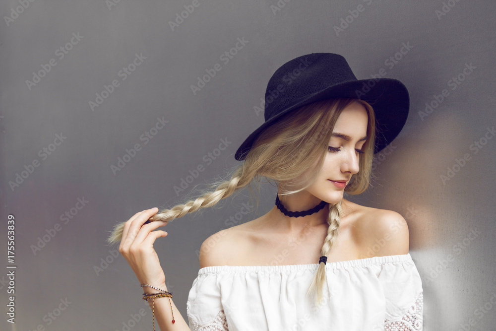 Close up of beautiful young blonde woman with black hat. Her hair is tied in two big ponytails. Around neck she has black choker. Close up of beautiful young blonde woman with black hat. Her hair is tied in two big ponytails. Around neck she has black choker.