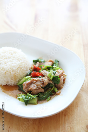 fried pork with Chinese Kale and rice on wood background , Thai food