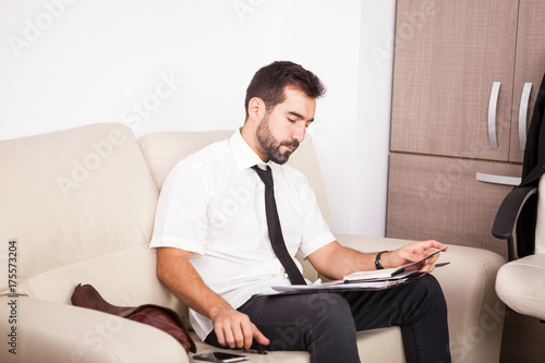 Businessman working in the office on the couch putting long hours of work. Businessperson in professional environment © DC Studio